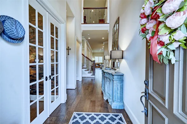 a hallway with painting on the wall and a potted plant