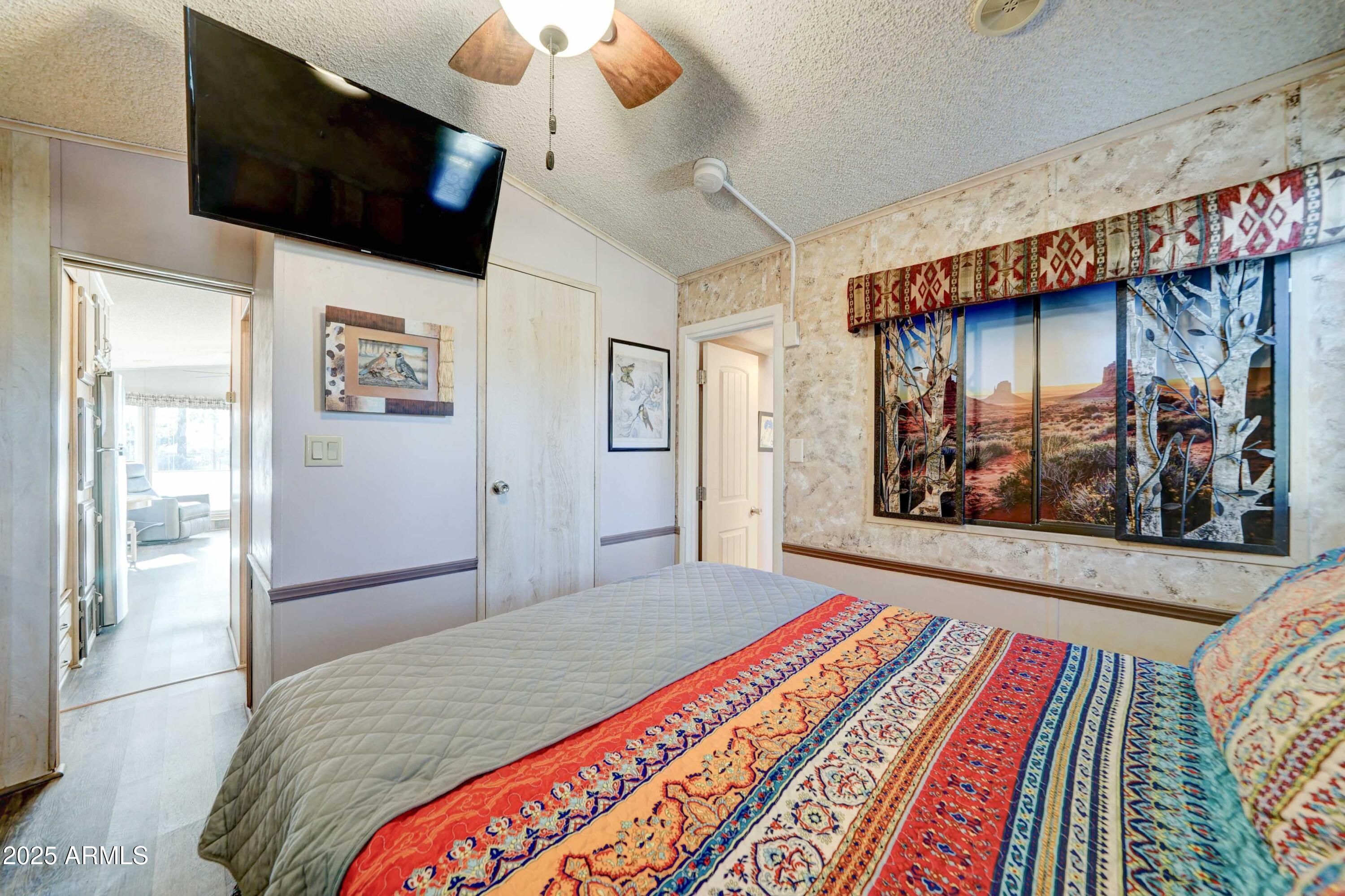 111 South Greenfield Road, Unit 633 Mesa, AZ 85206 - Photo 14 of 32 a bedroom with a bed and a flat screen tv