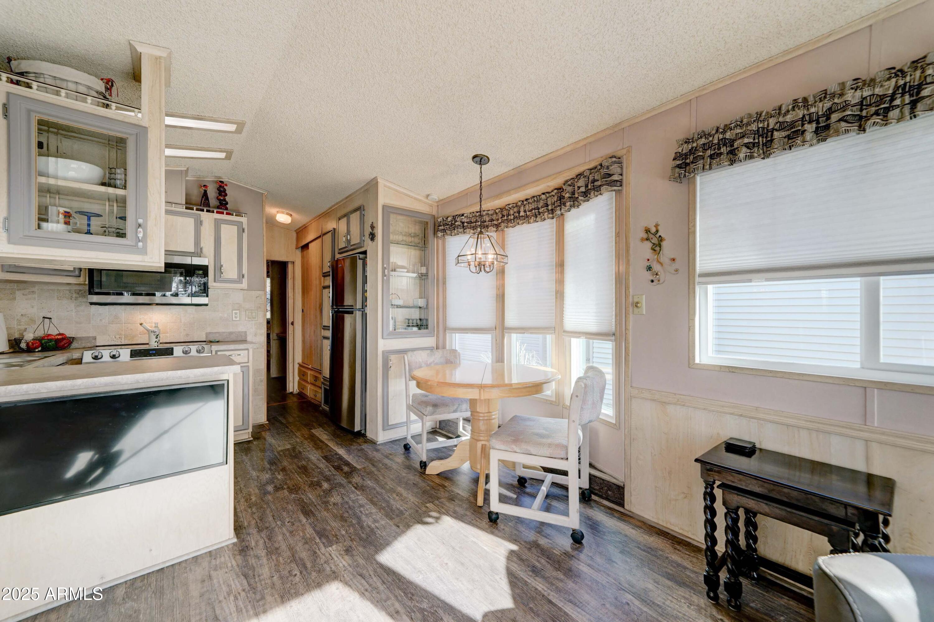 111 South Greenfield Road, Unit 633 Mesa, AZ 85206 - Photo 20 of 32 a kitchen with stainless steel appliances kitchen island a table chairs and a refrigerator
