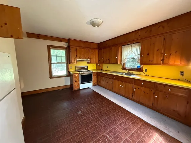 a large kitchen with stainless steel appliances granite countertop a sink and a stove
