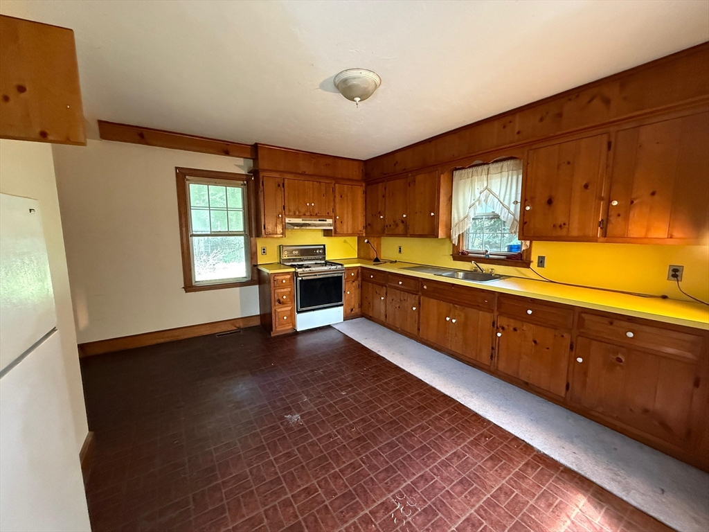 1143 Beacon Street, Unit 1 Newton, MA 02461 - Photo 2 of 4 a large kitchen with stainless steel appliances granite countertop a sink and a stove