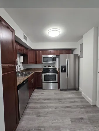 a kitchen with stainless steel appliances granite countertop a refrigerator and a stove