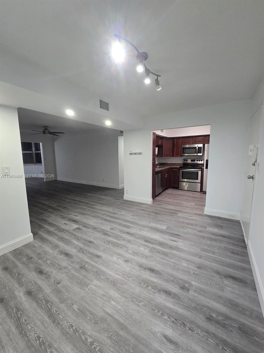 6500 Cypress Road, Unit 301 Plantation, FL 33317 - Photo 2 of 15 a view of empty room with wooden floor and fireplace