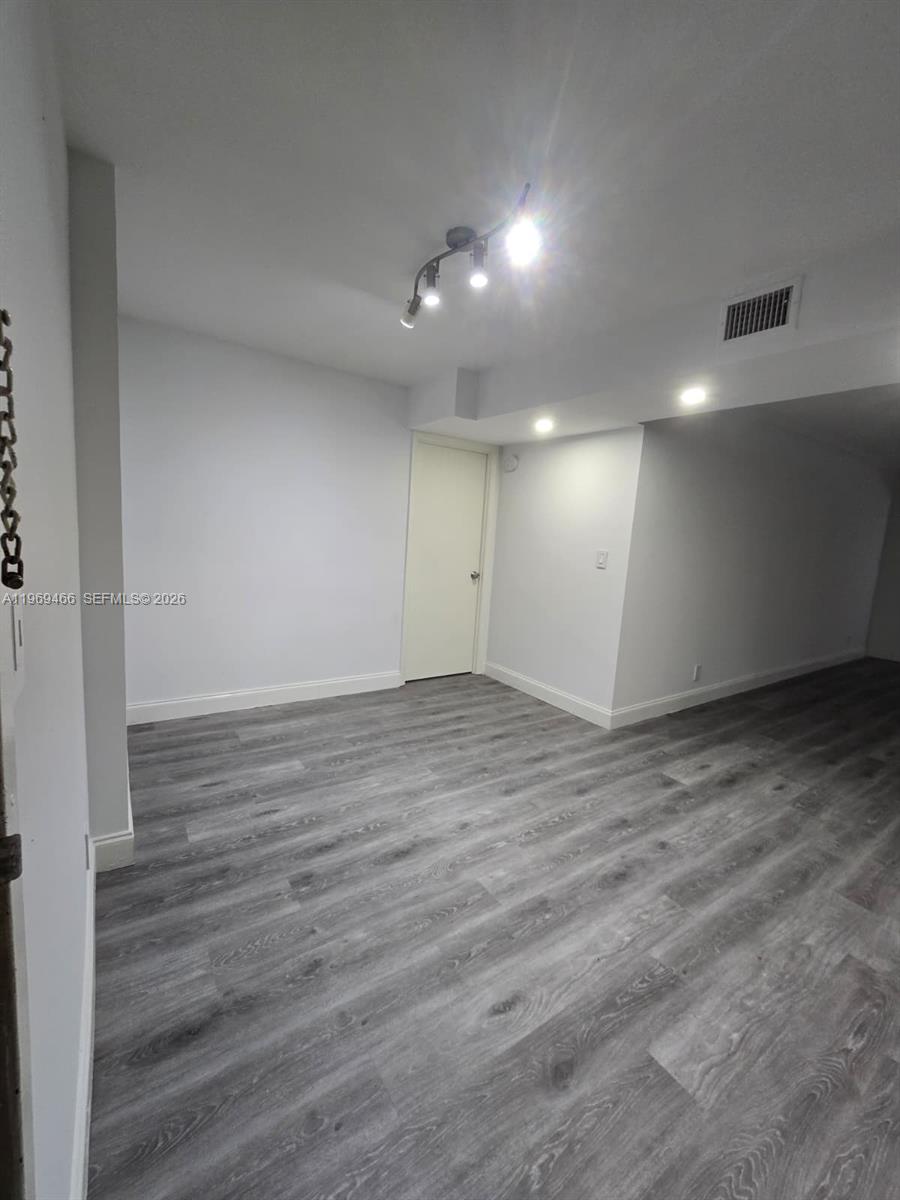 6500 Cypress Road, Unit 301 Plantation, FL 33317 - Photo 6 of 15 an empty room with wooden floor and windows