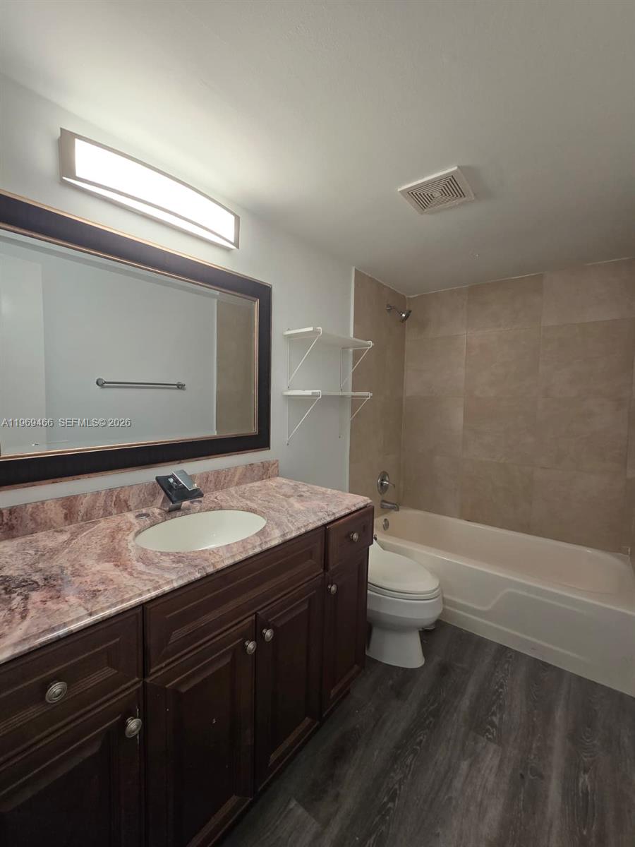 6500 Cypress Road, Unit 301 Plantation, FL 33317 - Photo 8 of 15 a bathroom with a granite countertop sink a toilet and a bathtub