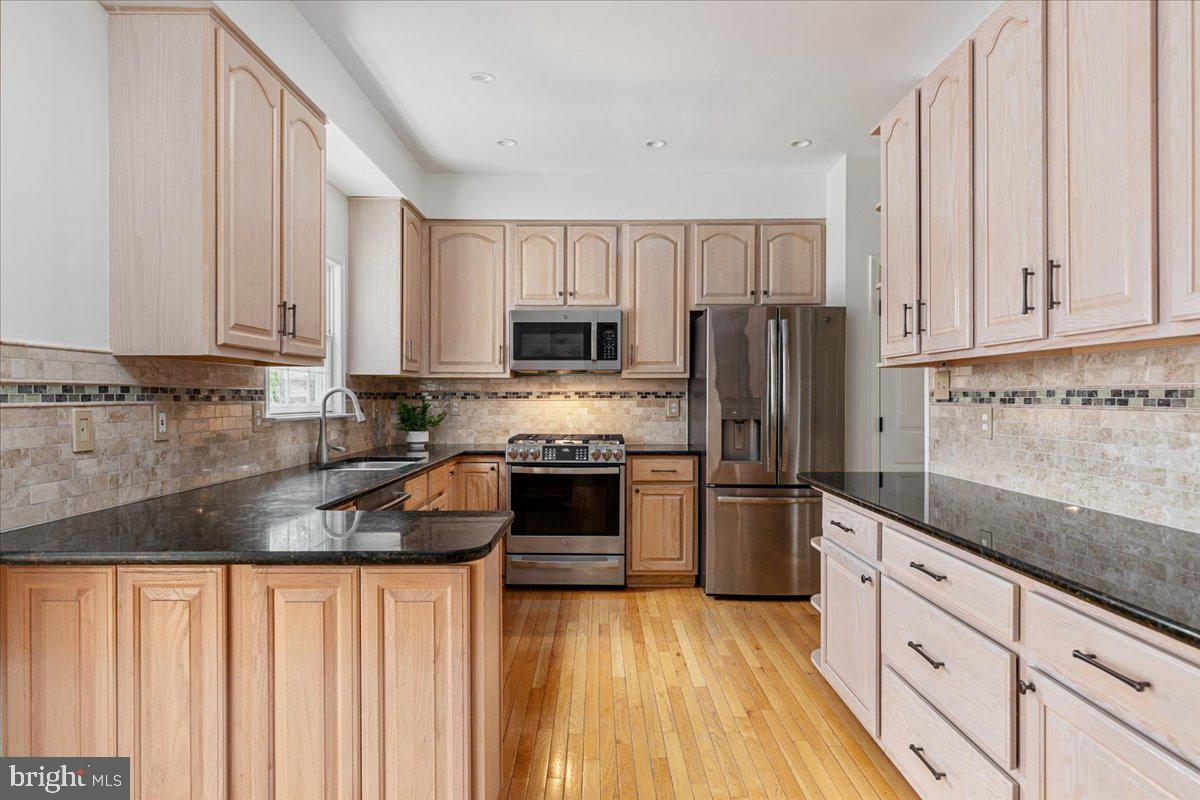 8747 Diamond Hill Drive Bristow, VA 20136 - Photo 4 of 38 a kitchen with granite countertop white cabinets and stainless steel appliances