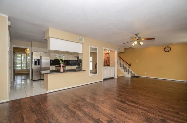 a view of a livingroom with furniture wooden floor and a kitchen