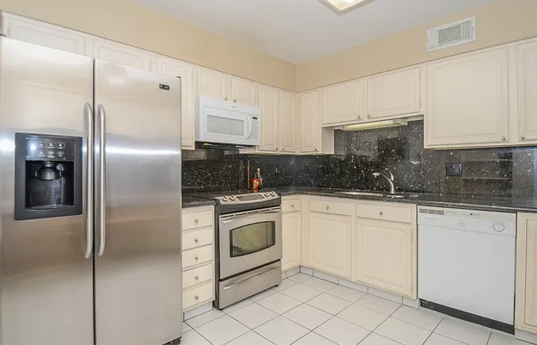 a kitchen with cabinets stainless steel appliances and a counter space