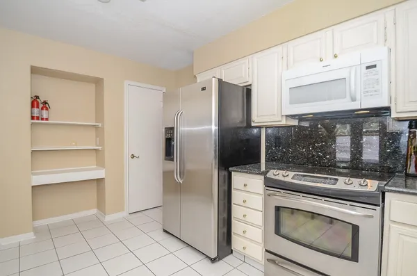 a kitchen with white cabinets and stainless steel appliances