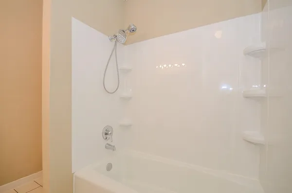 a bathroom with a bath tub with a shower
