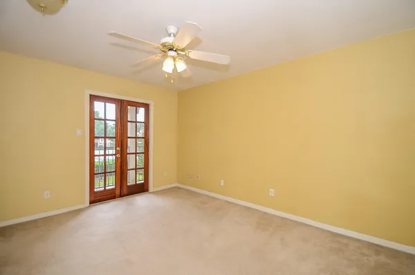 an empty room with windows and fan