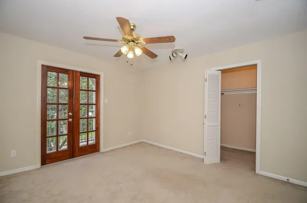an empty room with windows and fan