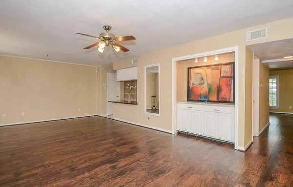 a view of a livingroom with wooden floor and a ceiling fan