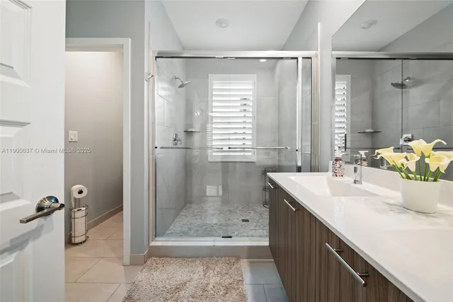 a bathroom with a shower sink vanity and toilet