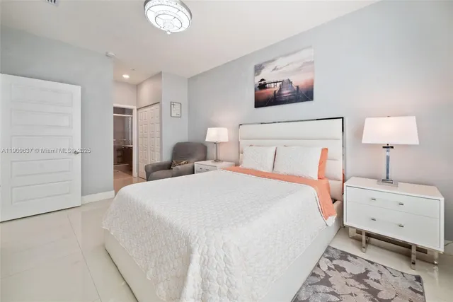 a bedroom with a large bed and a chandelier