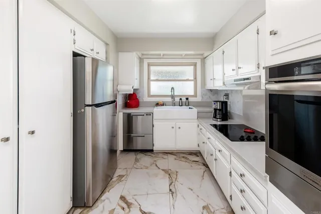 a kitchen with white cabinets and white appliances