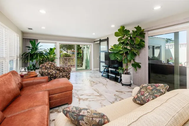 a bedroom with furniture a potted plant and a large window