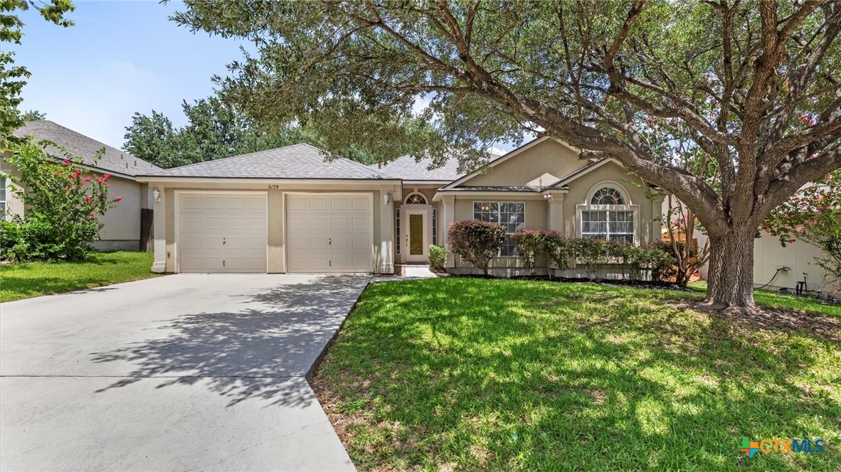 a front view of a house with a garden and trees