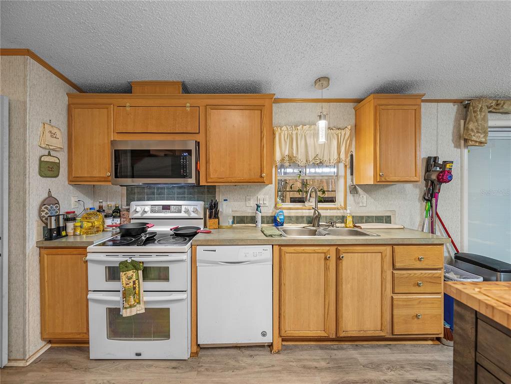 11404 Lithia Pinecrest Road Lithia, FL 33547 - Photo 19 of 63 a kitchen with stainless steel appliances granite countertop a stove top oven a sink dishwasher and cabinets with wooden floor