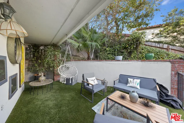 a view of a patio with couple of chairs and a fire pit