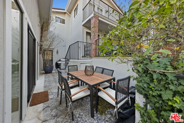 a view of a patio with table and chairs and potted plants