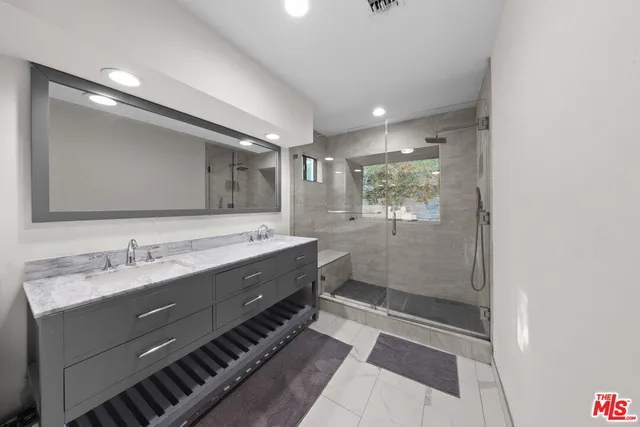 a bathroom with a double vanity sink and mirror