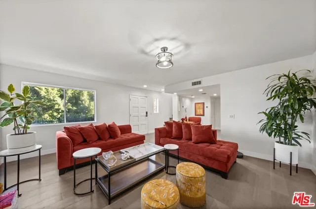 a living room with furniture a couch and a potted plant