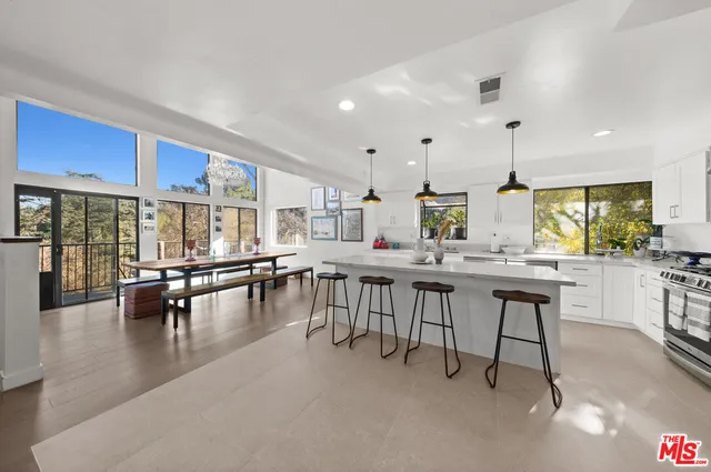 a kitchen with lots of counter and chairs