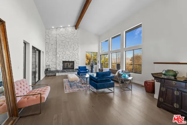 a living room with fireplace furniture and a large window