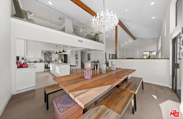 a room with stainless steel appliances kitchen island a table and chairs in it