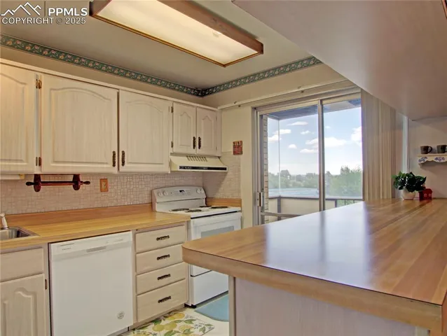 a kitchen with appliances cabinets and a large window