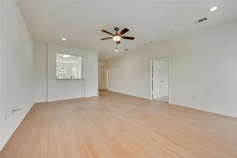 an empty room with fan and windows