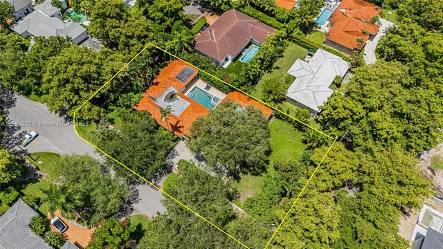 an aerial view of residential house with outdoor space and trees all around