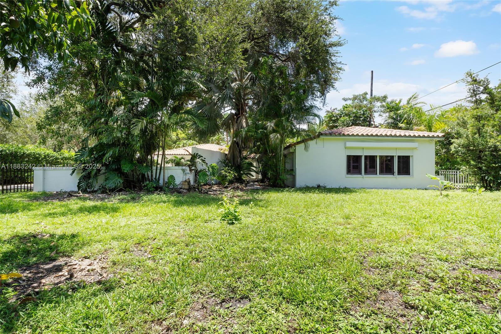 5810 Maggiore Street, Unit 5810 Coral Gables, FL 33146 - Photo 34 of 37 a backyard of a house with plants and large trees