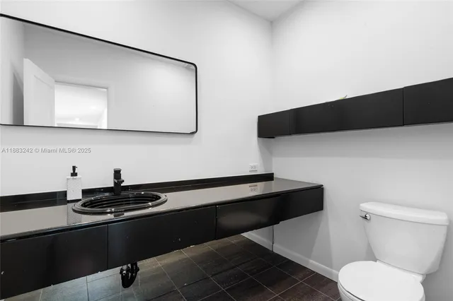 a bathroom with a sink toilet and a mirror