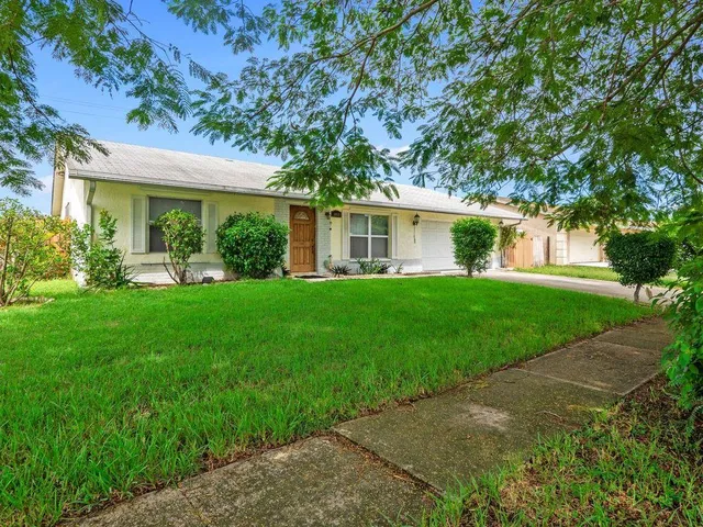 a front view of a house with a yard and trees