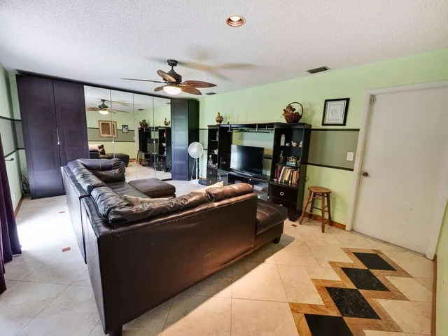a living room with furniture a flat screen tv and a dining table