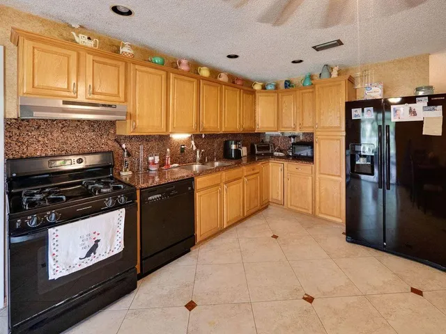 a kitchen with stainless steel appliances granite countertop a stove a sink and a refrigerator