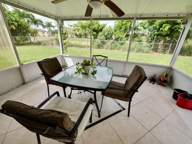 a view of a patio with lawn chairs next to a yard