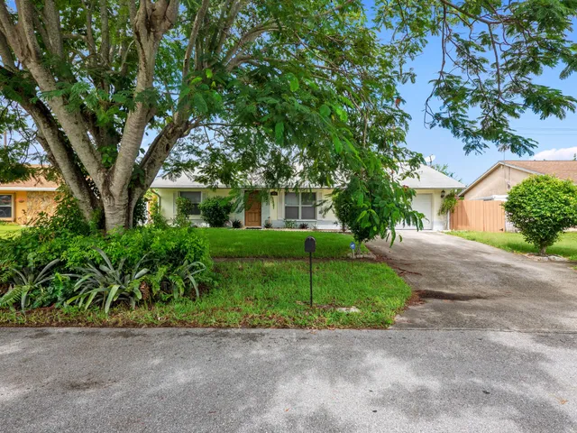 a front view of a house with a yard and a garage
