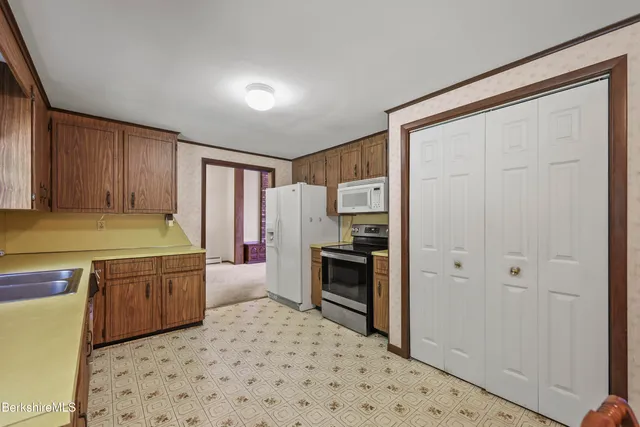 a kitchen with a refrigerator and a stove top oven