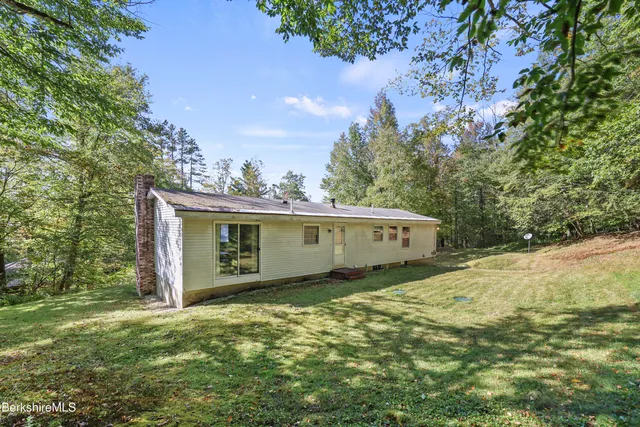 a front view of a house with a yard and trees