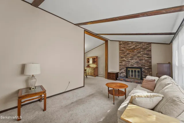 a living room with furniture a ceiling fan and a large window