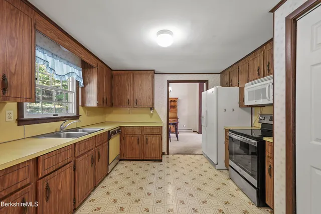 a kitchen with granite countertop a refrigerator and a sink