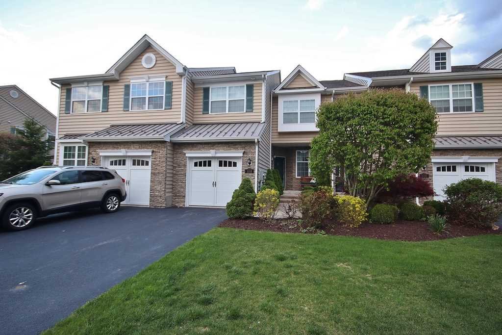 a view of a yard in front of a brick house with a large windows