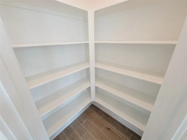 a view of a hallway with wooden floor and entryway