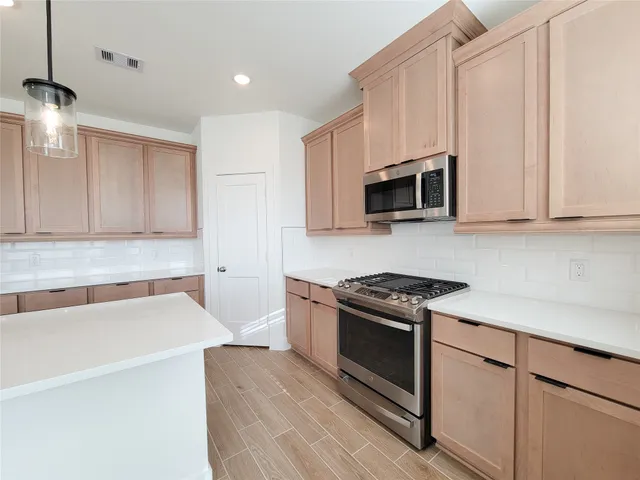a kitchen with granite countertop a stove and a microwave