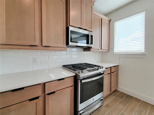 a kitchen with stainless steel appliances white cabinets and a stove top oven