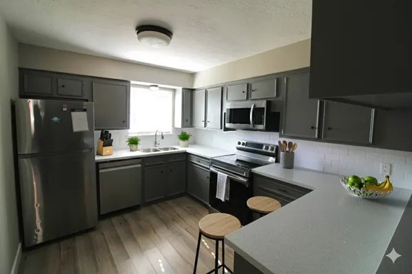 a kitchen with a refrigerator a stove a sink and chairs