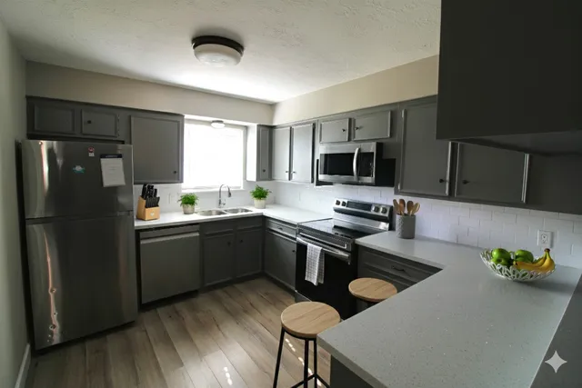 a kitchen with a refrigerator a stove a sink and chairs